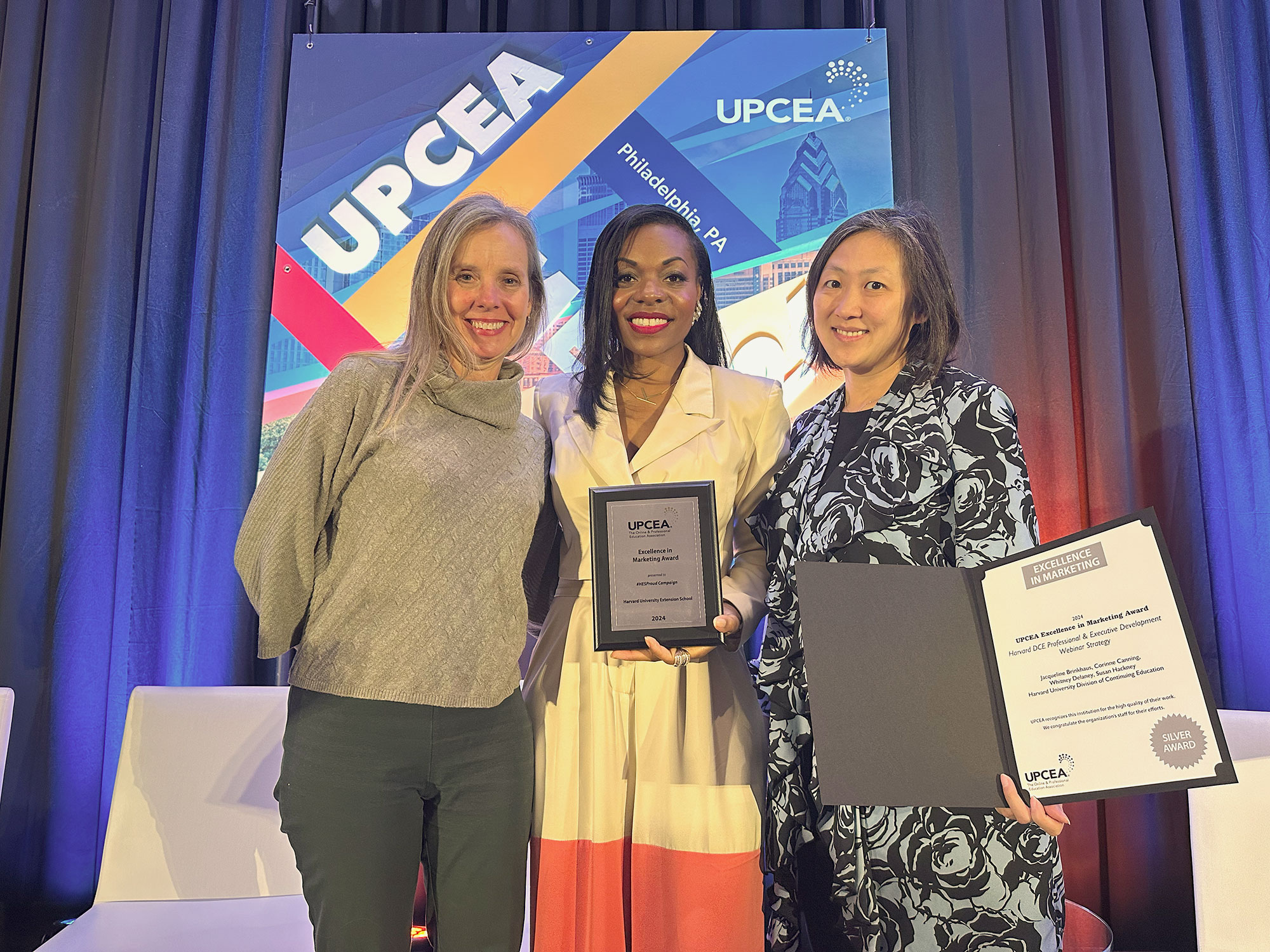Three people from the Harvard Division of Continuing Education Marketing team pose with awards.