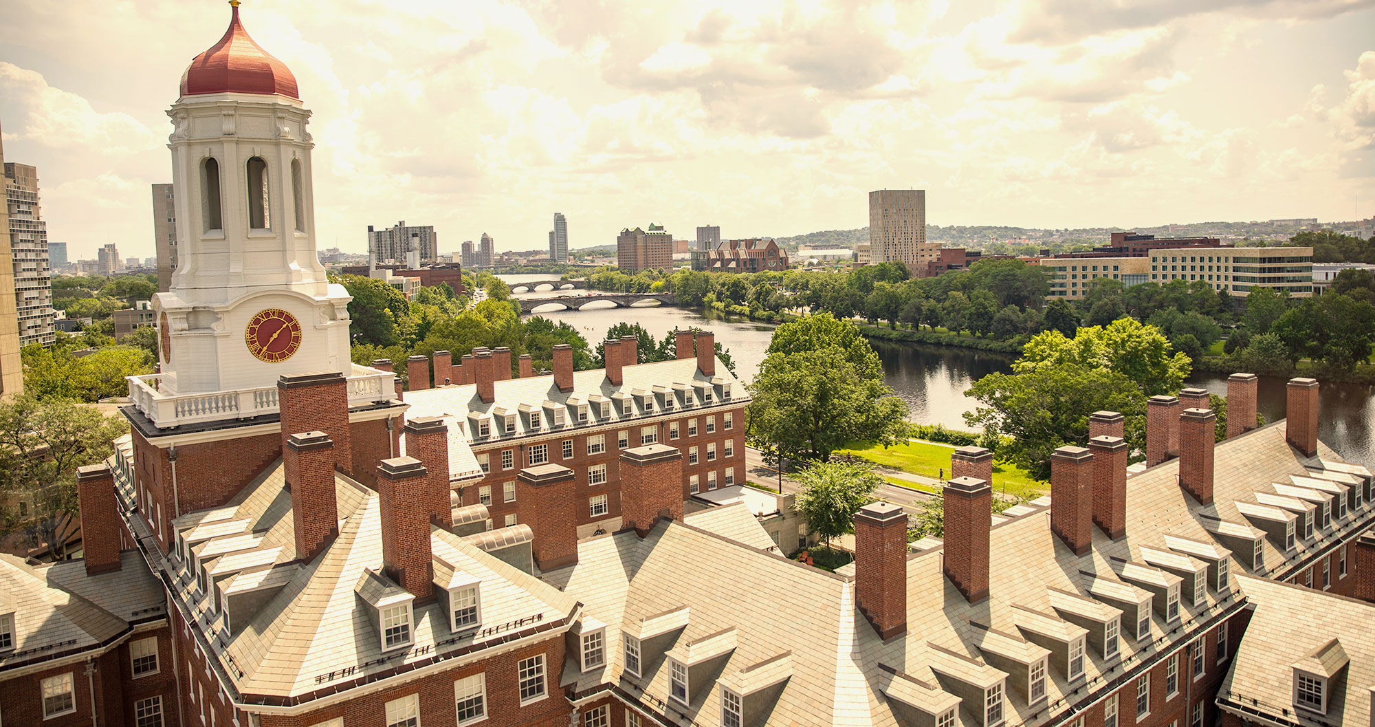 An aerial photo of Harvard's campus with the Boston skyline in the background.